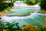 Kuang Si Waterfalls' cascading white foam over multiple rock tiers.