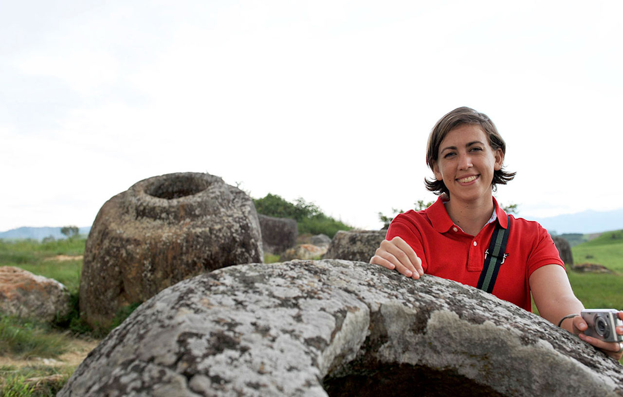 Large stone jars scattered across a grassy field, with hills in the background, Plain of Jars, Laos.