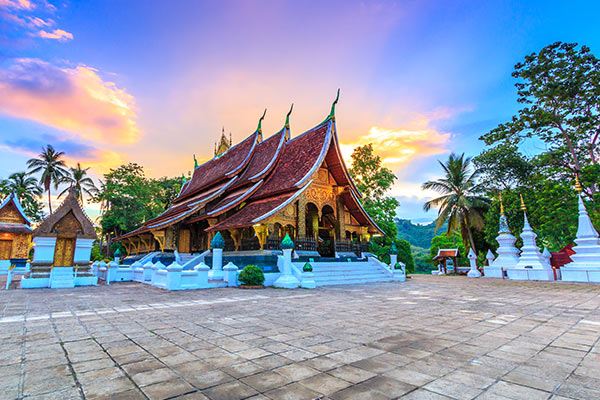 Exterior view of Wat Xieng Thong temple in Luang Prabang, showcasing its intricate architecture and golden decorations.