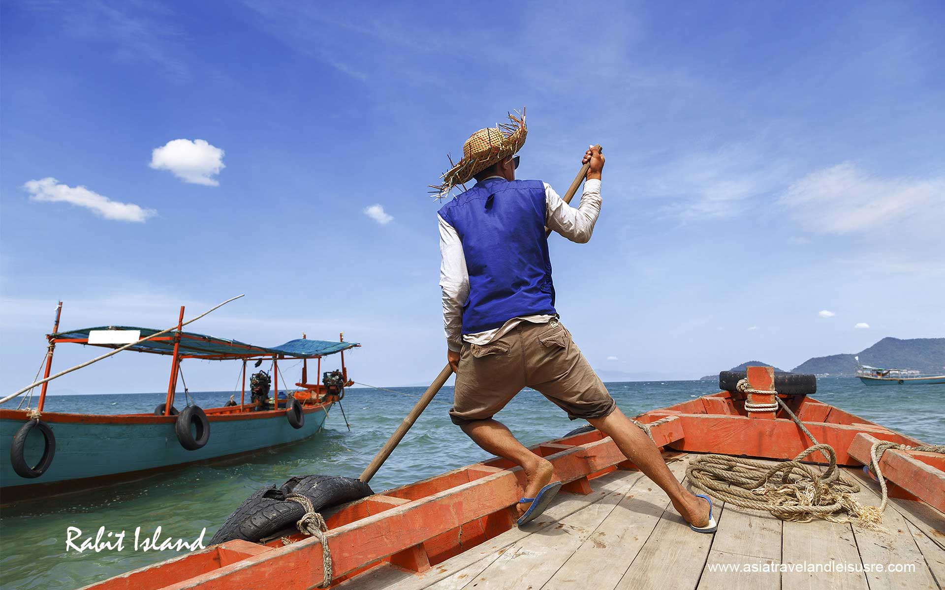 A person in a small boat enjoys a peaceful ride on the crystal-clear waters near Koh Tonsay (Rabbit Island), Cambodia